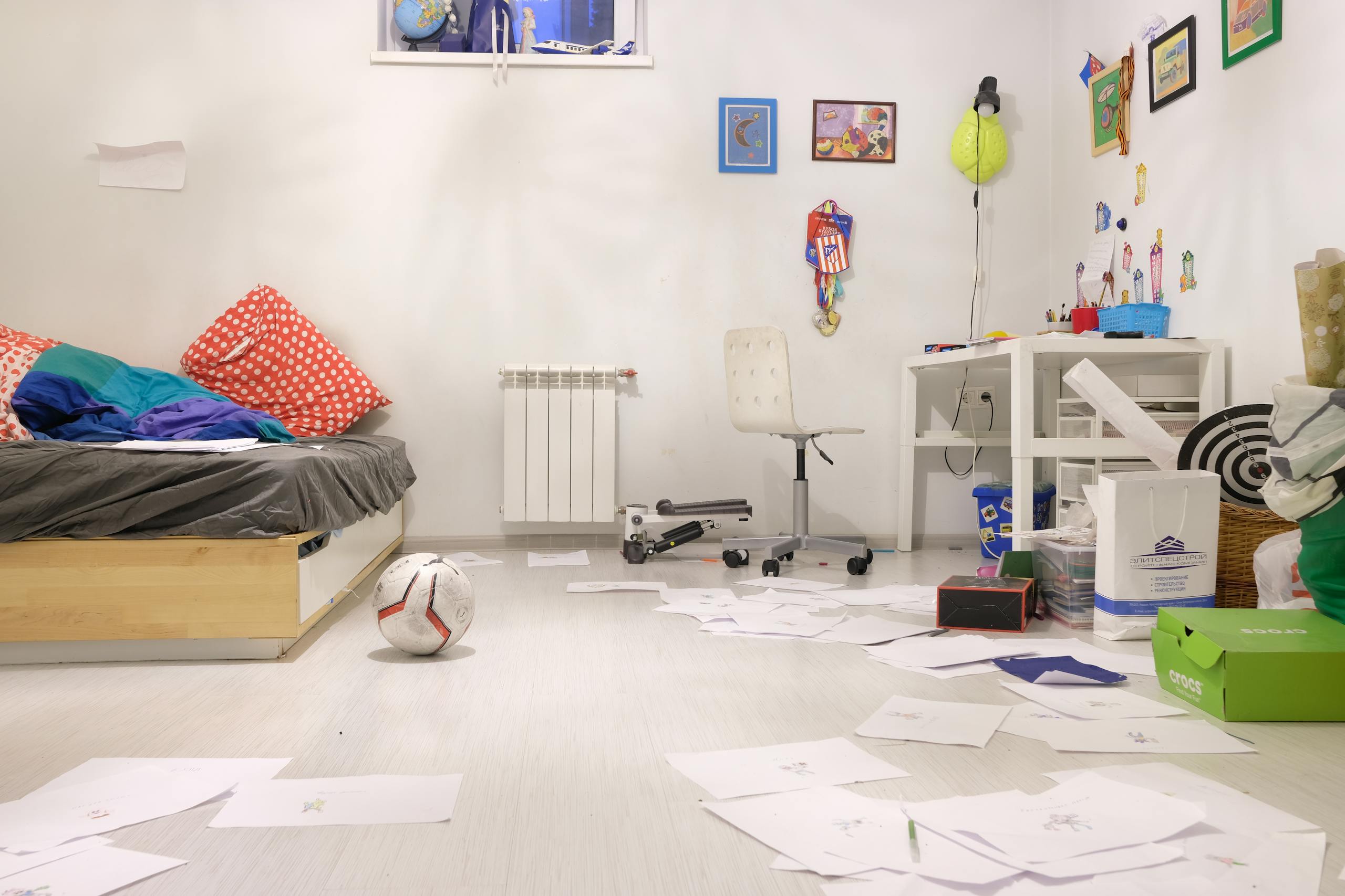 Messy kids' room with scattered papers and toys, showing lively disorder.